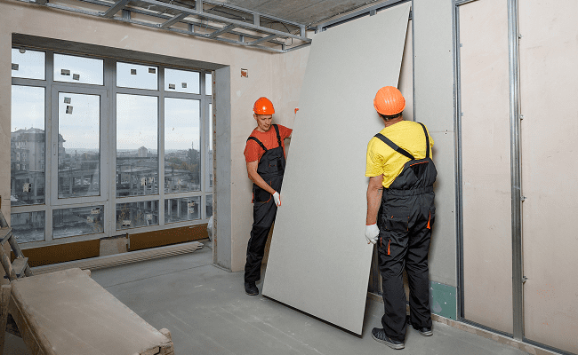 Drywall installation crew finishing walls in NYC commercial space